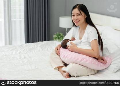 mother breastfeeding newborn baby on a support pillow cushion 