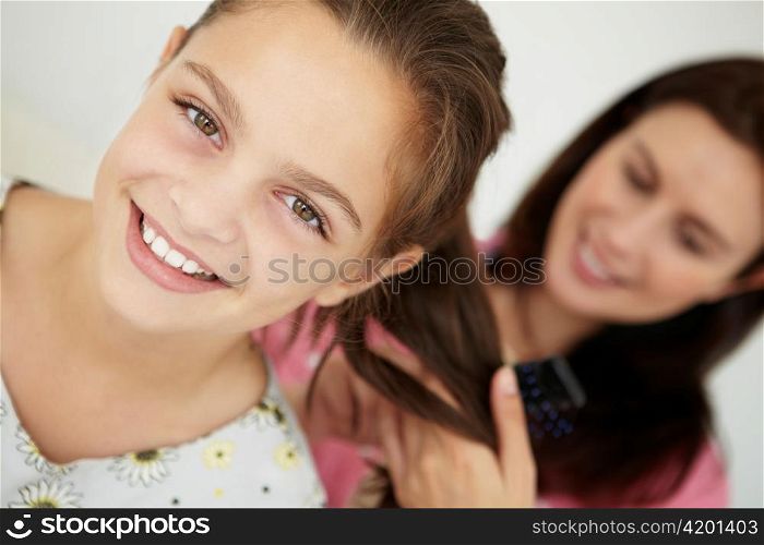 Mother brushing daughter&acute;s hair