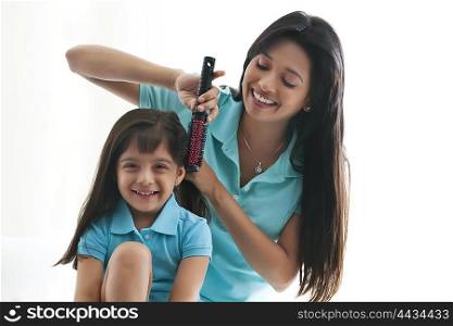 Mother brushing daughters hair