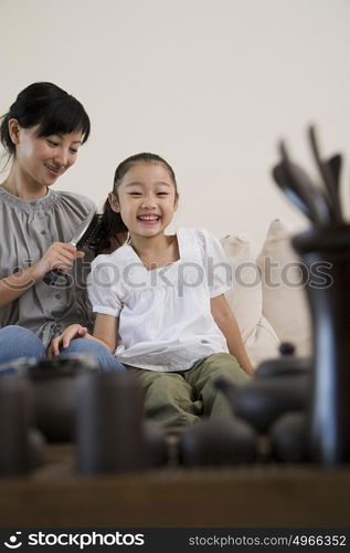 Mother brushing her daughters hair