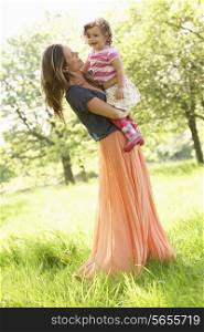 Mother Carrying Young Daughter Through Summer Field