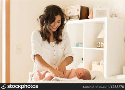 Mother changing a diaper on newborn baby