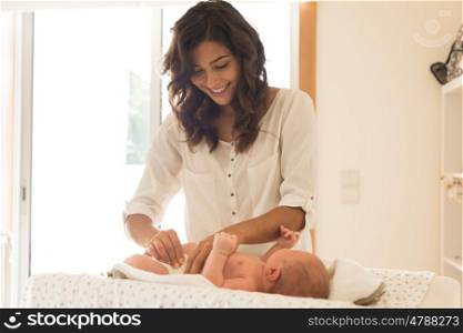 Mother changing a diaper on newborn baby