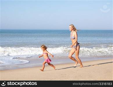 Mother chasing young girl on beach