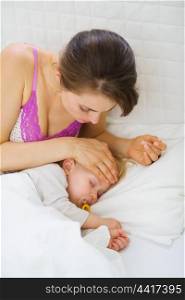Mother checking temperature of forehead of baby