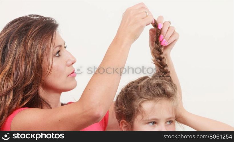 Mother combing daughter, care about hairstyle. Important role in child life.