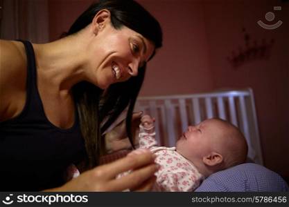 Mother Comforting Crying Baby In Nursery