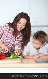 Mother cooking with son in kitchen