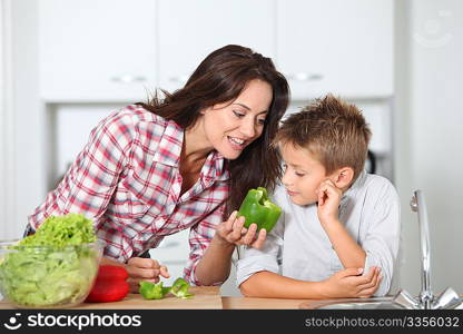 Mother cooking with son in kitchen