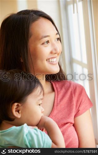 Mother Cuddling Young Son And Looking Out Of Window