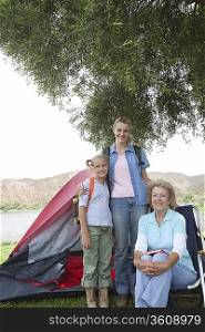 Mother daughter and grand-daughter stand outside tent