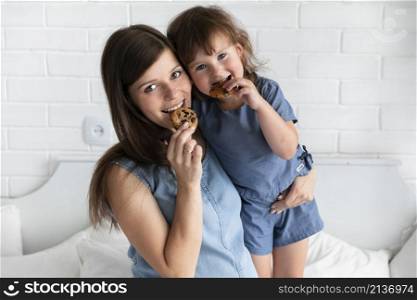 mother daughter eating chocolate cookies