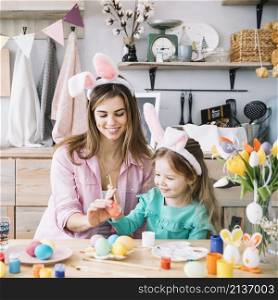 mother daughter painting eggs easter table