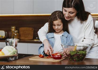 mother daughter preparing food kitchen
