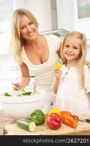 Mother & Daughter Preparing Salad In Modern Kitchen