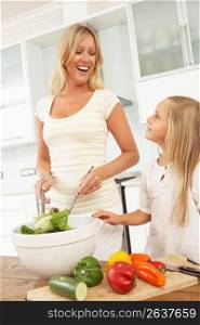 Mother & Daughter Preparing Salad In Modern Kitchen