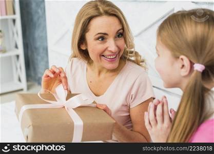 mother daughter sitting with gift box