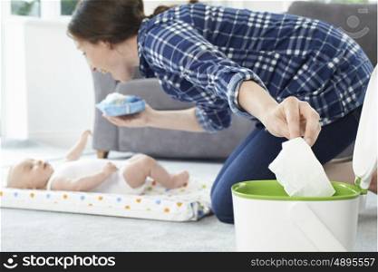 Mother Disposing Of Baby Wipe In Bin