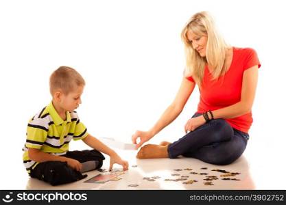 mother doing playing puzzle toy together with her son on floor isolated on white background