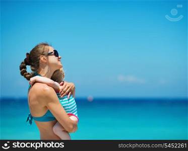 Mother embracing baby on beach