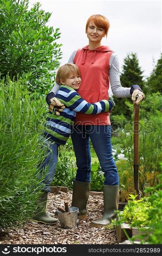 Mother embracing son (5-6) in garden, portrait