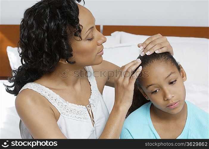 Mother examining daughter (7-9) in hospital