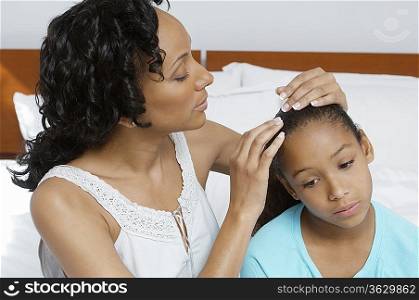 Mother examining daughter (7-9) in hospital