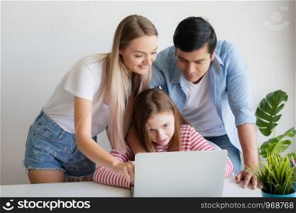 mother, father advise daughter for using laptop computer at home together at home, young family concept