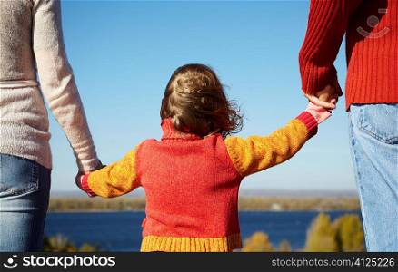 mother,father and daughter on nature background, focus on center