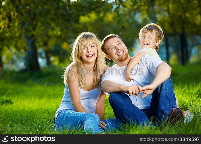 Mother, father and small son have a rest in park