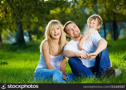 Mother, father and small son have a rest in park