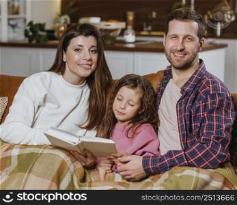 mother father reading book home with daughter