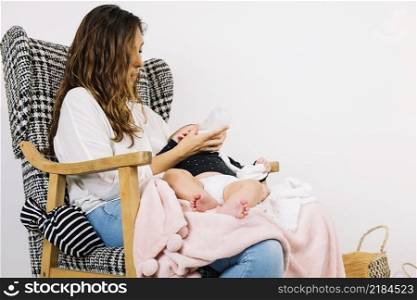 mother feeding baby armchair