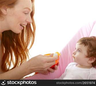 mother feeding baby yellow spoon white background