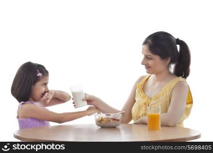 Mother feeding her daughter breakfast