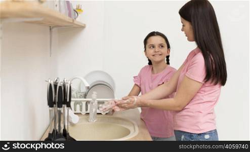 mother girl washing hands