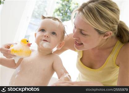 Mother giving baby bubble bath smiling