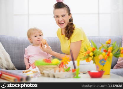 Mother giving baby Easter egg