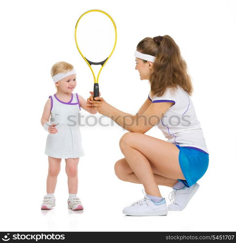 Mother giving baby tennis racket