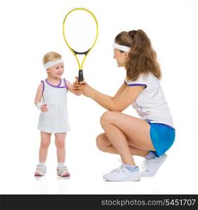 Mother giving baby tennis racket