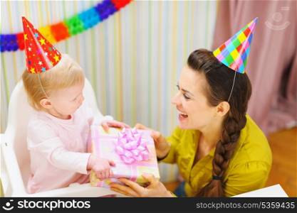 Mother giving birthday gift for baby