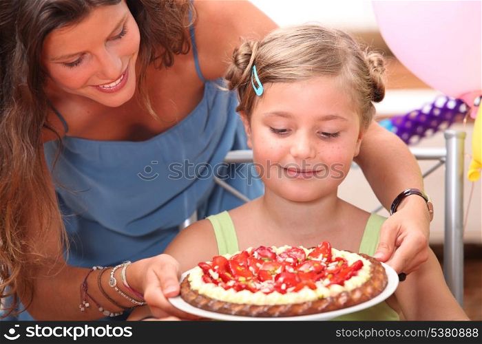 Mother giving daughter cake