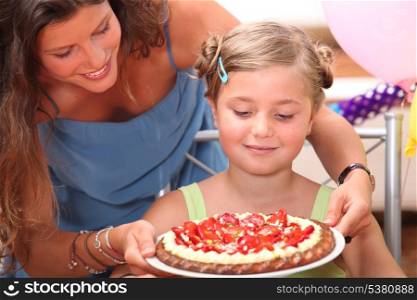 Mother giving daughter cake