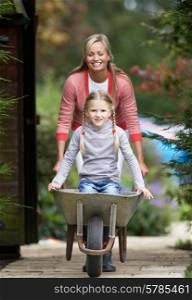 Mother Giving Daughter Ride In Wheelbarrow