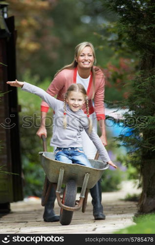 Mother Giving Daughter Ride In Wheelbarrow