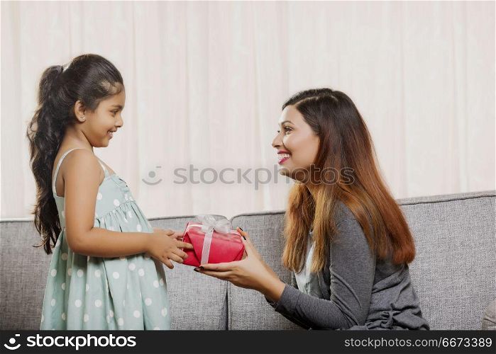 Mother giving gift to her daughter