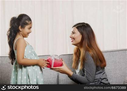 Mother giving gift to her daughter