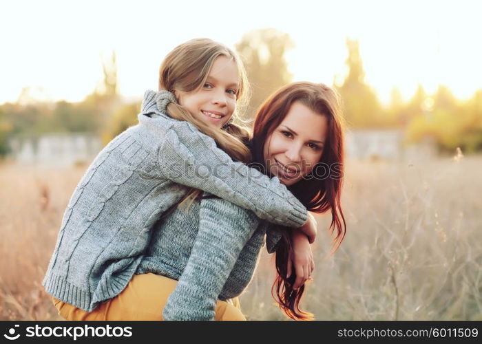 Mother giving her daughter a piggyback ride