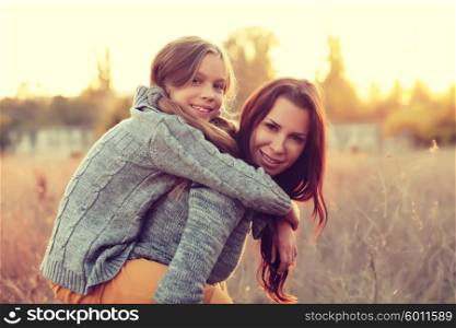 Mother giving her daughter a piggyback ride