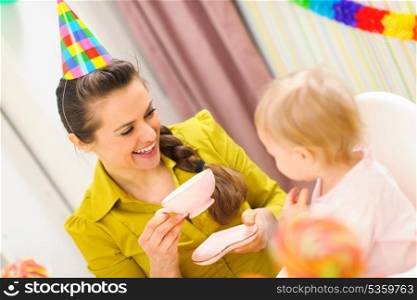 Mother having a tea on first birthday celebration of her baby